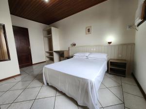 Un dormitorio con una gran cama blanca en una habitación. en Bomar Residence, en Bombinhas 49 fotos más