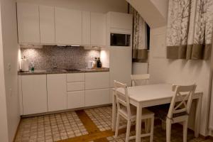a kitchen with white cabinets and a table and chairs at Modern Studios near City Center in Vienna +28 photos