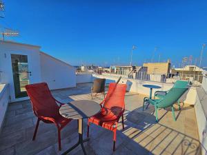 a patio with chairs and a table on a roof at RomAntica in Polignano a Mare