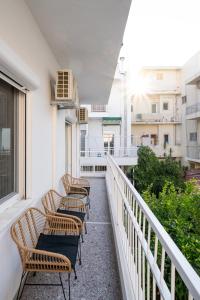 a row of chairs sitting on a balcony at Modern Apartment in the heart of Kos Town in Kos Town