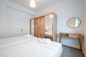 a bedroom with two beds and a mirror at Modern Apartment in the heart of Kos Town in Kos Town