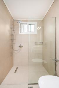 a bathroom with a glass shower with a toilet at Modern Apartment in the heart of Kos Town in Kos Town +6 photos