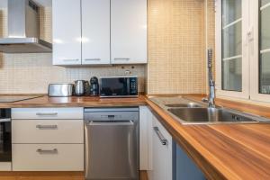 a kitchen with white cabinets and a stainless steel sink at Blue Door Algarve - Guest House in Portimão +39 photos