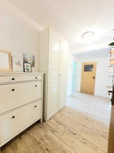 オストルダにあるApartament Parkowyのドレッサーのある寝室と廊下のある部屋