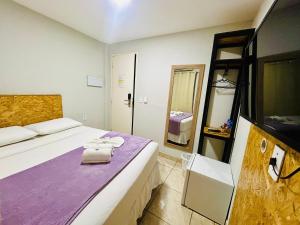 een hotelkamer met een bed en een spiegel bij Mansomar in Jericoacoara