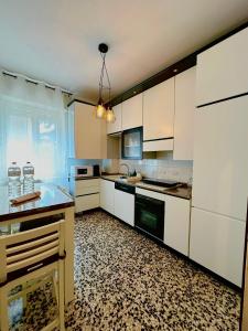 a kitchen with white cabinets and a black and white floor at Spacious, minimalist, chic "Maison de Fleurs" in Malgrate
