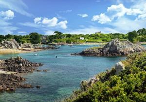 a river with rocks and people in the water at Charmante Maison sur le port Loguivy de la Mer in Ploubazlanec