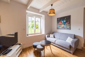 a living room with a couch and a table at Charmante Maison sur le port Loguivy de la Mer in Ploubazlanec
