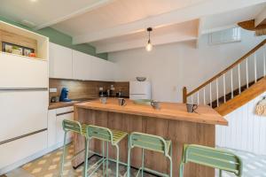 a kitchen with a wooden counter and green chairs at Charmante Maison sur le port Loguivy de la Mer in Ploubazlanec +26 photos