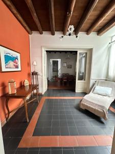 Habitación con paredes de color naranja, cama y mesa. en Dionigi suite, en Siracusa