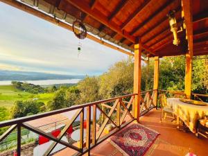 a balcony with a table and a view at Varsovia, casa de madera biblioteca in Guatavita
