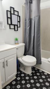 a bathroom with a toilet and a shower curtain at Eight Street Apartments in Long Beach +12 photos