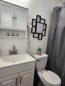 a bathroom with a sink and a toilet and a shower at Eight Street Apartments in Long Beach