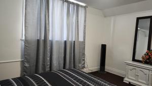 a bedroom with a bed and a window with a mirror at Eight Street Apartments in Long Beach