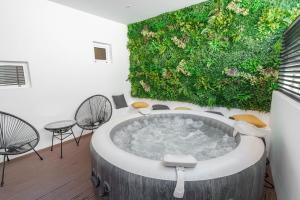 a bathroom with a large tub with a green wall at Kition Urban Suite 2 in Larnaca