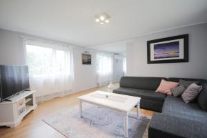 Una sala de estar con un sofá y un televisor. en Esplanaadi Villa, en Pärnu