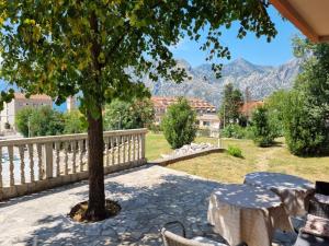 a patio with a table and chairs and a tree at Bosko in Kotor