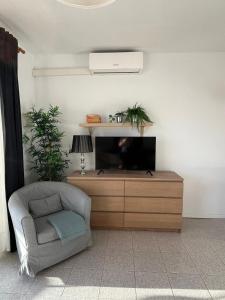 a living room with a chair and a television at CRÁTER 2 in El Paso