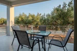 a table and chairs on a balcony with a view at Alonakia Home Suites in Filiatra