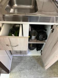 eine Küchenschublade mit Spüle und einigen Töpfen und Pfannen in der Unterkunft Apartamento Bella Vista Gramado in Gramado