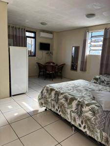 ein Schlafzimmer mit einem Bett und einem Tisch darin in der Unterkunft Apartamento Bella Vista Gramado in Gramado + 92 Fotos