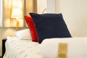 a bed with red and black pillows on it at SeaSide Sopot - butikowe noclegi przy plaży in Sopot