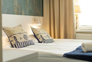 a white bed with two pillows on top of it at SeaSide Sopot - butikowe noclegi przy plaży in Sopot