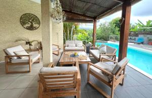 a patio with a table and chairs and a pool at Villa Ti MoOn, Piscine et Jaccuzi, idéalement situé, Sud Réunion in Entre-Deux +29 photos