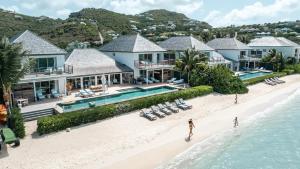 古斯塔维亚Le Barthélemy Hotel & Spa的海滩上房屋的空中景致