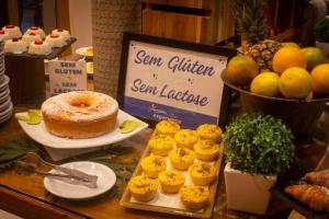 a table with a sign and some food on it at Hotel Experience João Fernandes in Búzios