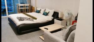 a bedroom with a bed with a couch and a chair at Super View in Pattaya South