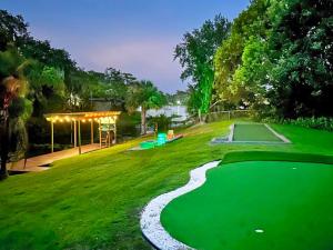 a golf course with a putting green at night at Lakefront 7 Bedroom Duplex, Pool, Boat, and Hottub in Orlando
