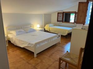 a bedroom with two beds and a table and a chair at Casa Laura in Porto Garibaldi