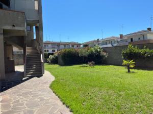 a grassy yard next to a building with a staircase at Casa Laura in Porto Garibaldi