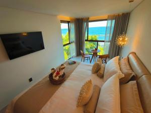 a bedroom with a large bed with a view of the ocean at Almareia Boutique Hotel in Praia dos Carneiros