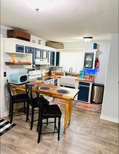 a kitchen with a wooden table and black chairs at Cici's Guest House in Laurel
