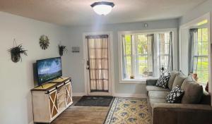 a living room with a couch and a flat screen tv at Cici's Guest House in Laurel