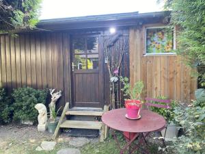 a wooden shed with a table and a wooden door at Chambre à la venelle in Caen