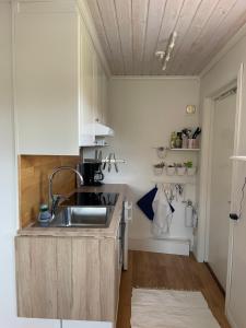 a kitchen with white cabinets and a sink at Boende med vackra omgivningar in Borlänge +9 photos