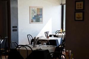a group of tables and chairs in a room at Hotel BELLA ROMAGNA in Casal Borsetti