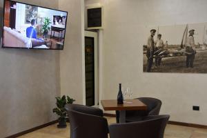 a living room with a tv and a table and chairs at Hotel BELLA ROMAGNA in Casal Borsetti