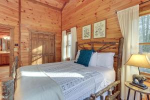 ein Schlafzimmer mit einem Bett in einer Blockhütte in der Unterkunft Secluded Cherry Log Cabin with Hot Tub and Swings! in Cherry Log
