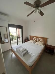 a bedroom with a bed with a ceiling fan at Duplex aconchegante na Riviera - próximo à praia in Bertioga