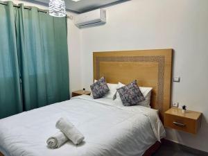 a bedroom with a large white bed with green curtains at Cozy Family House in City-Center in Chefchaouene +24 photos