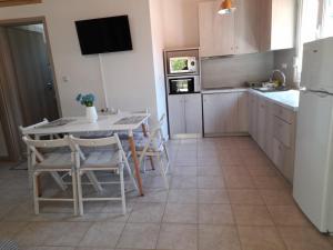 a kitchen with a table and chairs and a refrigerator at Dimitra House in Metamorfosi