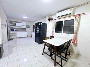 Una cocina con una mesa y sillas en una habitación. en K T Greenvill, en Ban Khom 7 fotos más