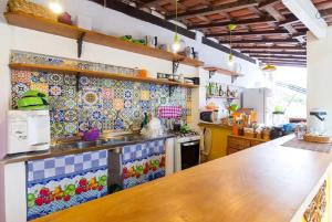 a kitchen with colorful tiles on the wall at Maracujá Hostel in Paraty +23 photos