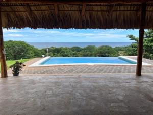 a swimming pool with a view of the ocean at Rancho Agua Fria in Jucuarán +13 photos