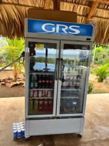 Una gasolinera con un refrigerador CBS lleno de bebidas. en Rancho Agua Fria, en Jucuarán