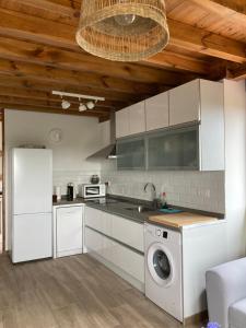 a kitchen with white cabinets and a washing machine at Apartamentos Rio Loba Ruiloba costa Cantabria in Ruiloba